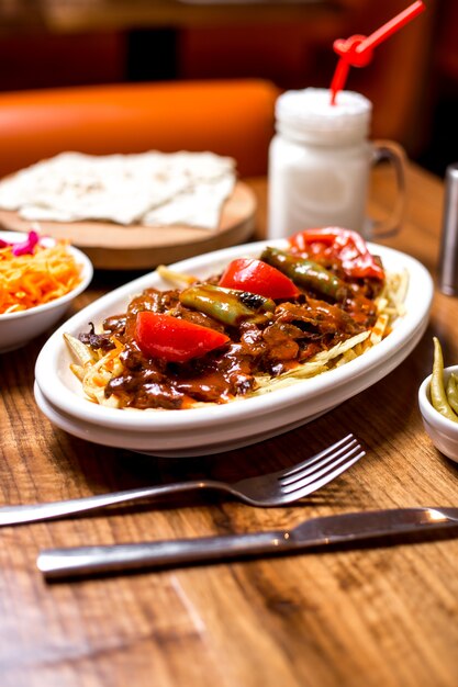 무료 사진 매운 토마토 소스 구운 야채와 함께 garnished 터키어 쇠고기 케밥