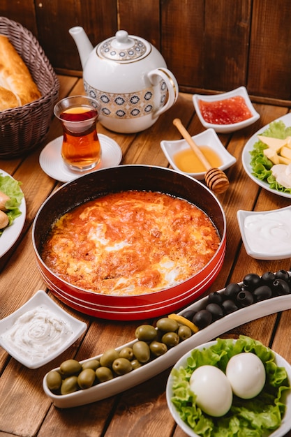 Free photo turkish breakfast setup with egg and tomato dish sausages olives eggs and tea