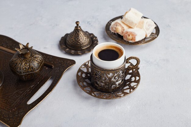Turkish coffee set served with lokum in metallic platter. 