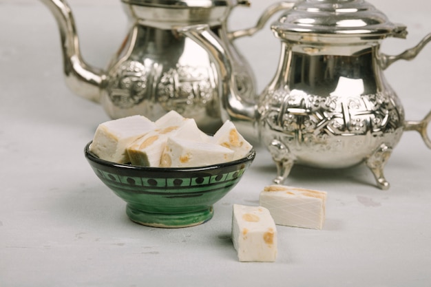 Free photo turkish delight in bowl with teapots on table