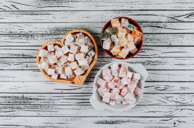 Turkish delight lokums in a bowls on a white wooden background. top view.