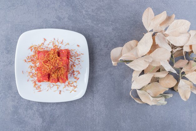 Turkish delight rahat lokum on white plate over grey background.