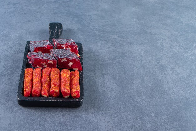 Turkish delights on a board , on the marble background.