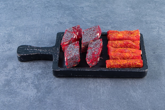 Turkish delights on a board , on the marble background.