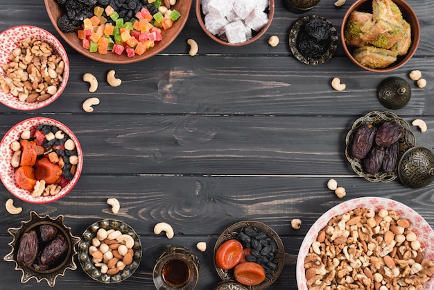 Turkish dessert baklava; lukum with dried fruits and nuts on wooden table with copy space in the center