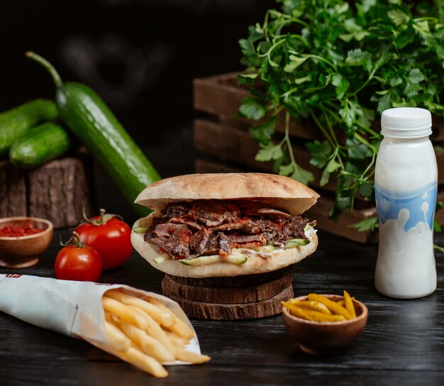 Turkish doner inside round bread with french fries and yogurt