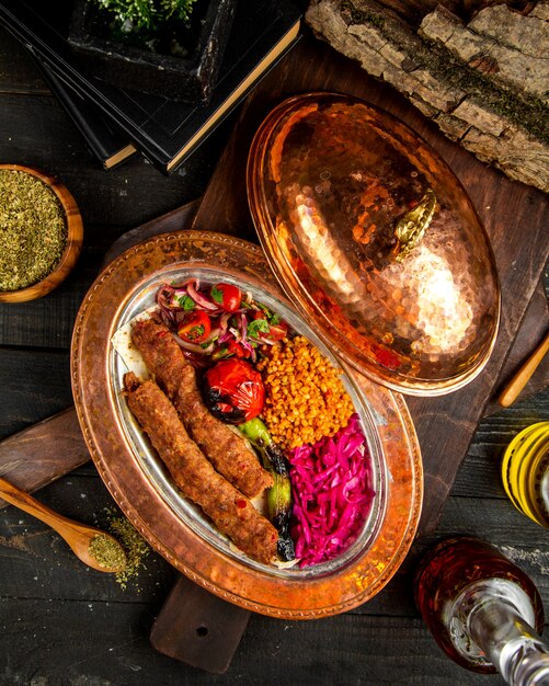 Turkish kÃ¶ftÉ with bulgur and vegetables top view