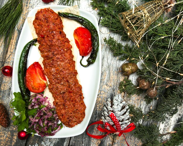 Turkish kebab with bell pepper tomato meat and spice served with grilled pepper and tomato