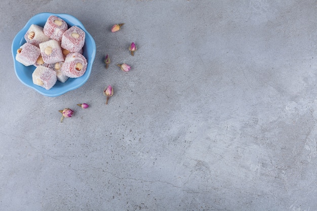 Turkish lokum with hazelnuts placed on a wooden piece . 