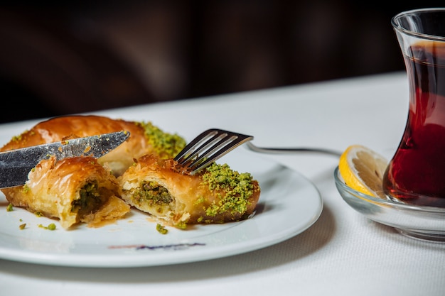 Free photo turkish pakhlava with pistacios served with black tea