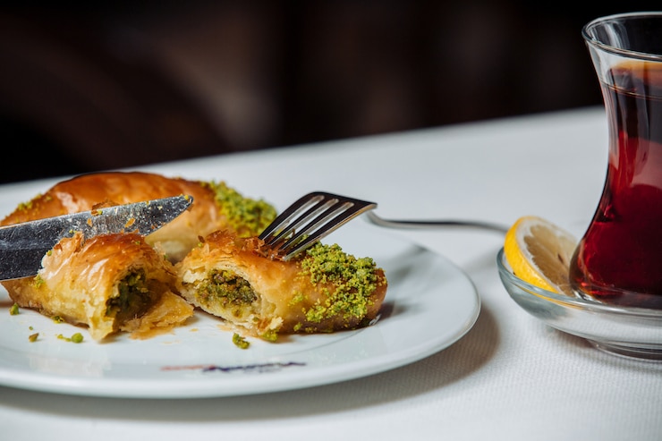 Free Photo turkish pakhlava with pistacios served with black tea