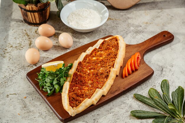 turkish pide flatbread with minced meat and tomato topping