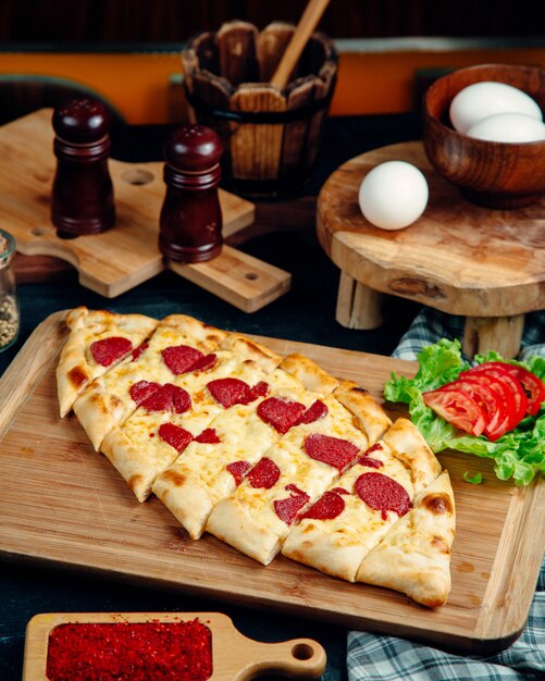 Turkish pide garnished with cheese and pepperoni