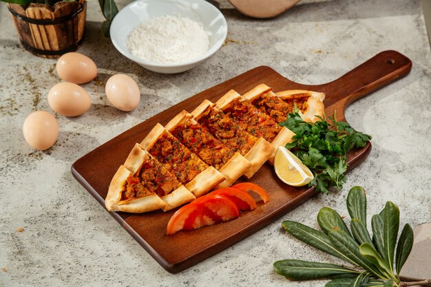 Turkish pide served with tomatoes, parsley and lemon