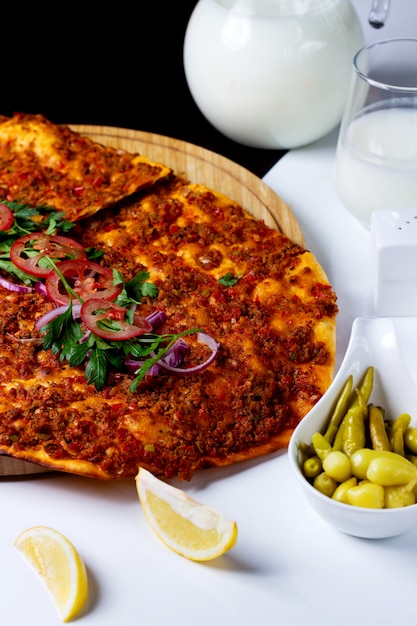 Free photo turkish pizza lahmajun garnished with tomato onion rings and parsley