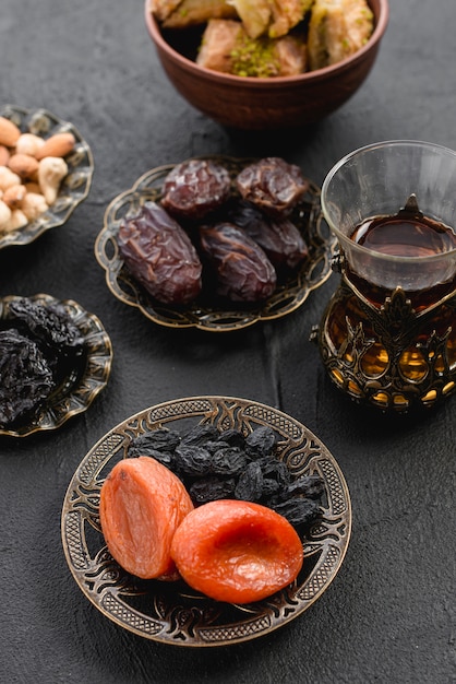 Turkish tea with dates and dried apricot; raisin in an arabian iron plate for ramadan