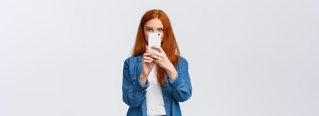 Turning on photo filter cheerful and cute female redhead lifestyle blogger taking picture on smartph