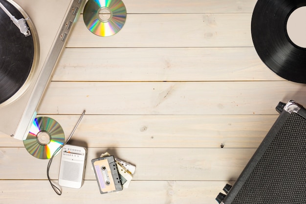 Turntable vinyl record player; compact disc; cassette tape and radio on wooden table