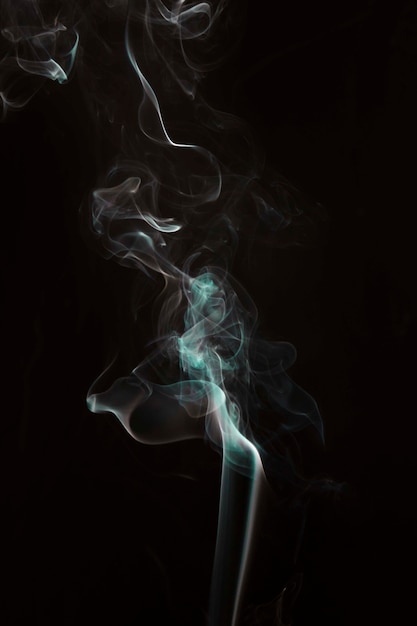 Turquoise smoke against black dark background