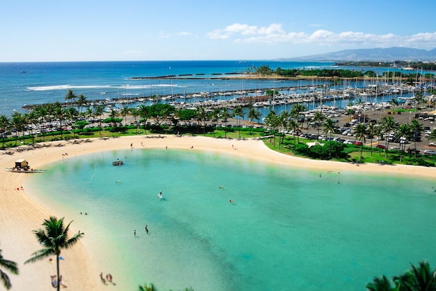 Turquoise water touches golden shores where people rest