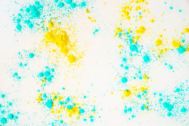 Turquoise and yellow color powder on white background