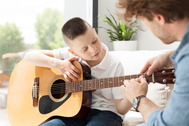 Tutor and boy playing guitar