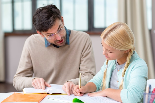 Tutor and girl at home writing new information