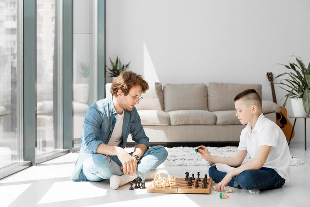 Tutor learning boy how to play chess long view