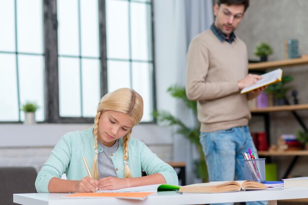 Tutor reading a book and standing