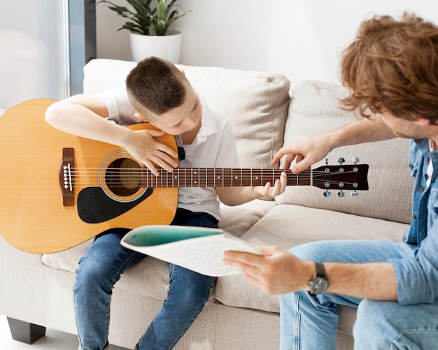 Репетитор показывает ученику, как держать руку на гитаре