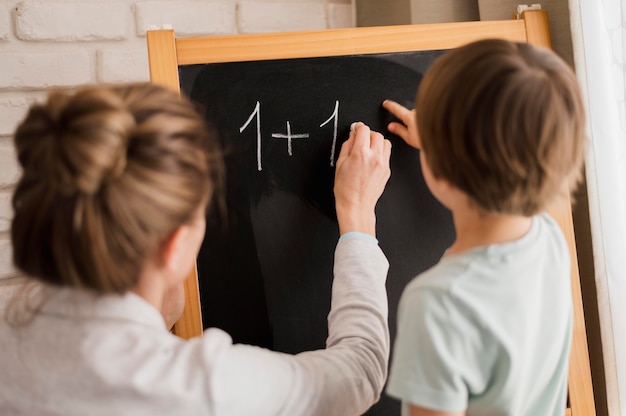 Free photo tutor teaching child at home mathematics