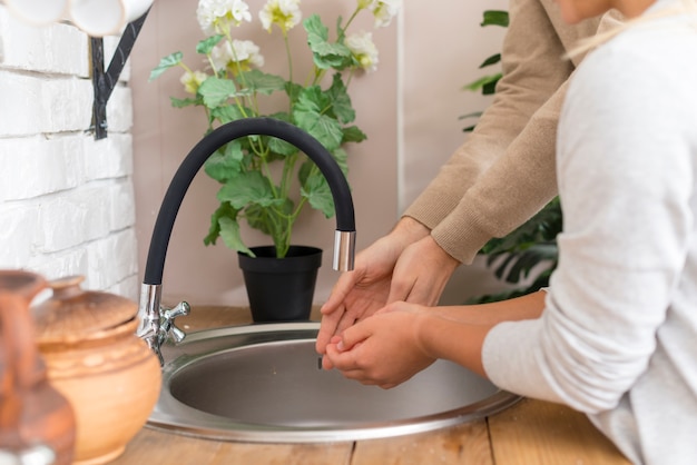 Tutor and young student washing their hands