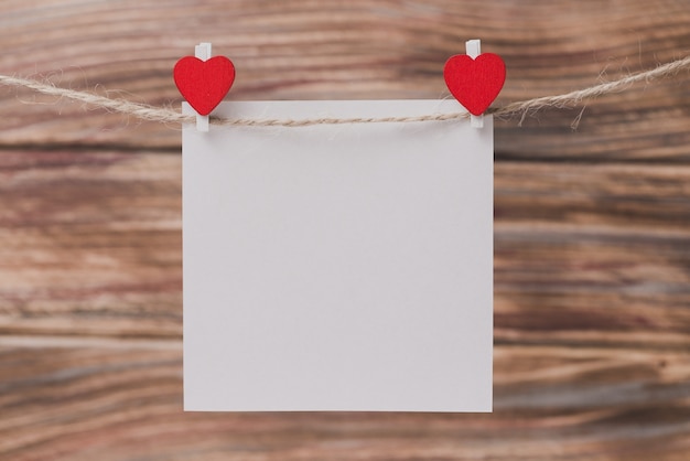 Free photo tweezers with a heart holding a paper
