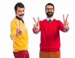 Free photo twin brothers doing victory gesture