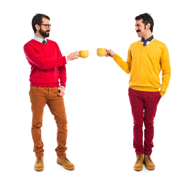 Free photo twin brothers holding cups of coffee