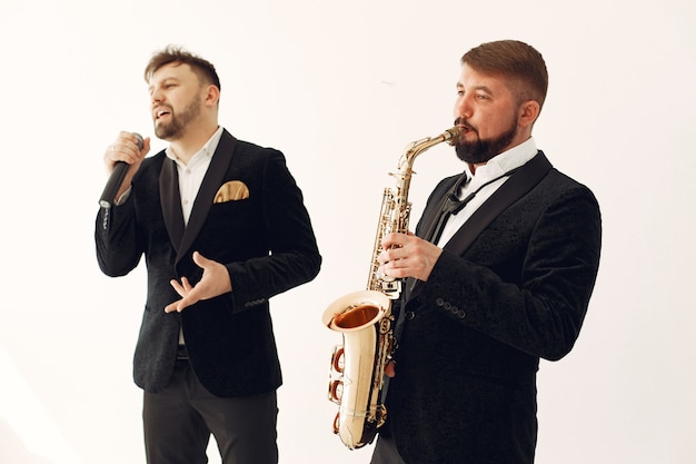 Free photo two adult  musicians standing in studio