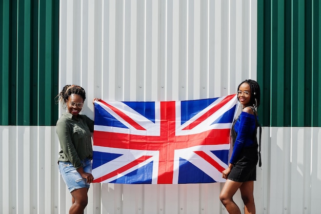 Foto gratuita due ragazze afroamericane con la bandiera della gran bretagna sulle mani