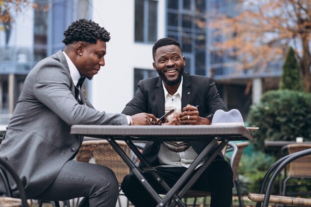 Two african businessman sitting outside cafe