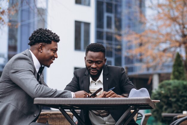 Two african businessman sitting outside cafe