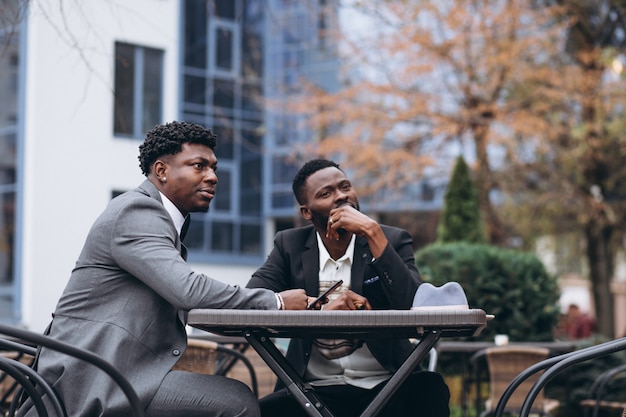 カフェの外に座っている2つのアフリカの実業家