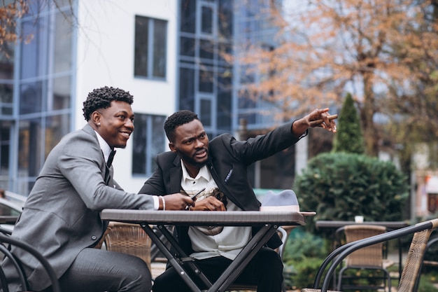 Two african businessman sitting outside cafe