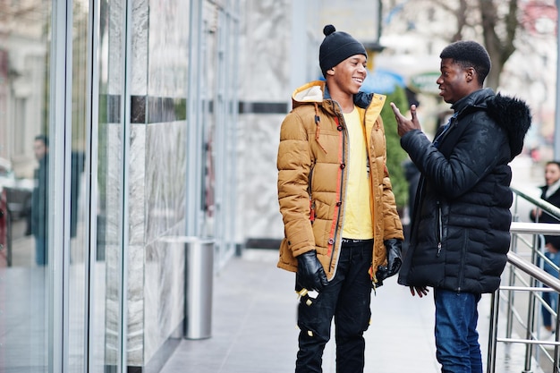 Free photo two african male friends talking together wear on jackets at cold weather