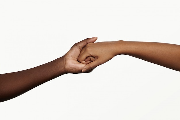 Two African people holding their hands tight together.