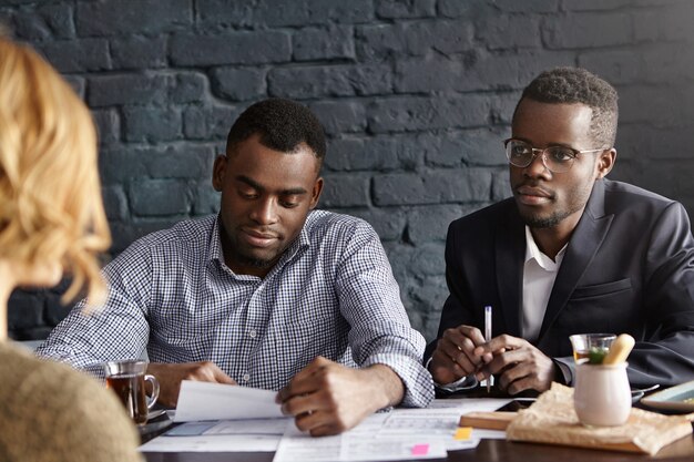 Two African recruiters interviewing unrecognizable woman candidate