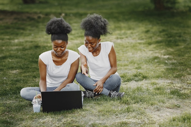 2人のアフリカ系アメリカ人の姉妹が公園で休んでいます