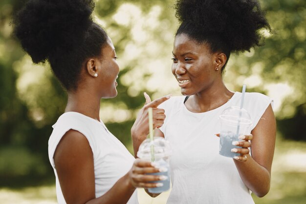 Две афроамериканские сестры отдыхают в парке
