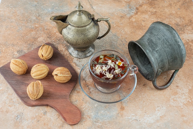 Free photo two ancient teapots with sweet cookies on marble background