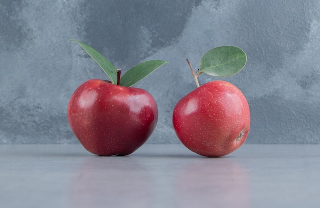 Two apples displayed on marble . 