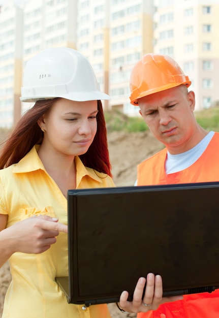 Two architects  works in front of building site