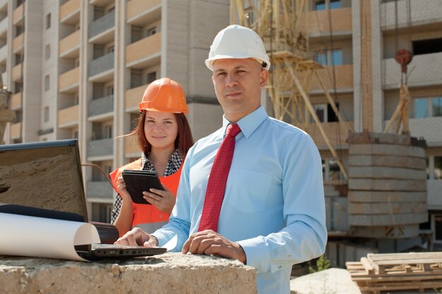 Two architects works in front of building site